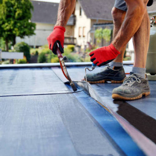 roofer applying a roof coating